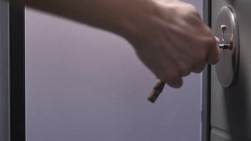 Female Hand Locking or Unlocking Door with Key