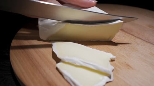 Close-up of Female Cook or Housewife Cutting Cheese with a Knife, Slow Motion
