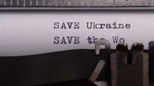 Typing phrase "SAVE Ukraine SAVE the World" on retro typewriter.