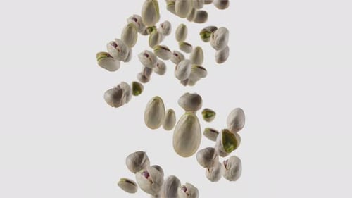 Pistachios Falling in Slow Motion Against White Background