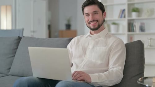 Young Adult Working On Laptop At Home