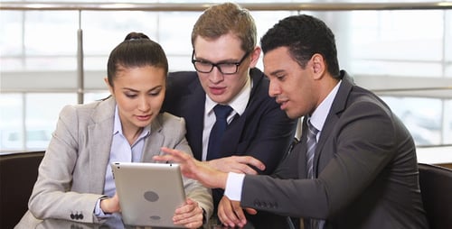 Businesspeople Share Tablet at Modern Table