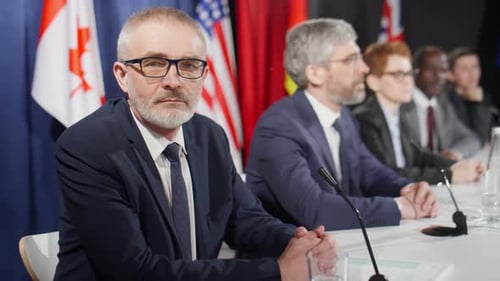 Politicians Sitting at a Table with Microphones