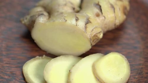 Close Up of Ginger and Slices on Wood