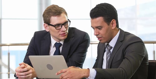 Two Professionals Collaborating on a Laptop at Work