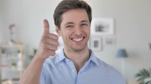 Man Giving Thumbs Up Gesture in an Indoor Setting