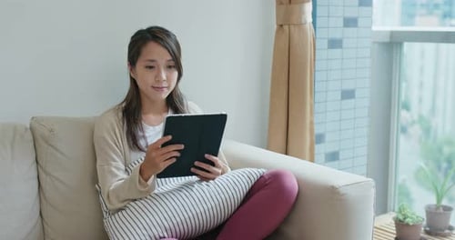 Woman Using Tablet on Couch at Home