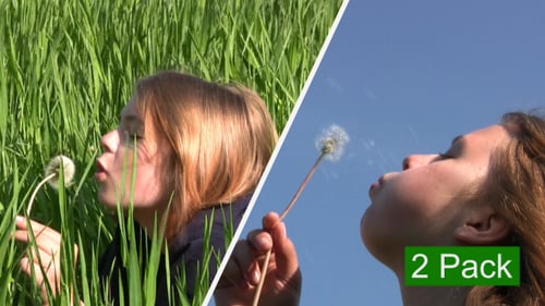 Girl Blowing Dandelion in Lush Green Field