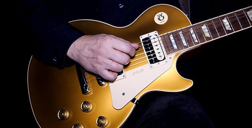 Close Up of Gold Electric Guitar Being Played