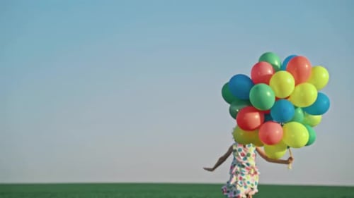 Happy Child Running with Colorful Balloons in Field