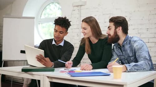 Young African Guy Showing the Results of His Work to His Collegues