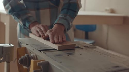 Person Smooths Wood on Woodworking Machine in Workshop