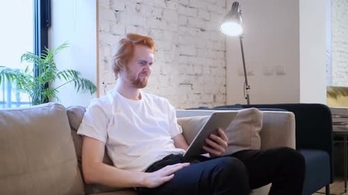 Reaction to Loss by Creative Man Using Tablet in Office