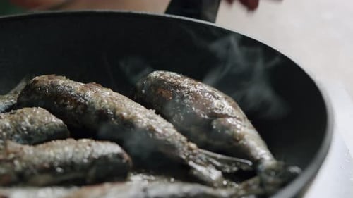 Small Fish Cooking in Frying Pan with Steam