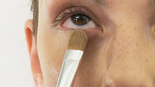 Adult Applying Concealer with Brush Close Up