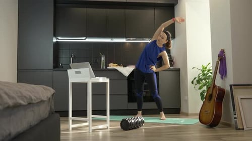 Woman Stretching on Yoga Mat at Home