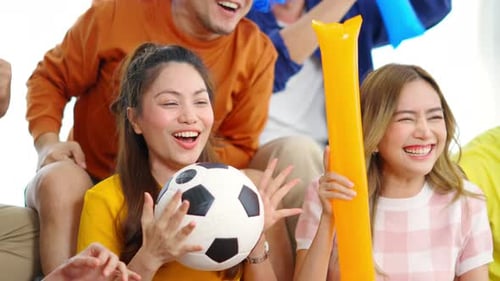 Enthusiastic friends watching soccer game together at home