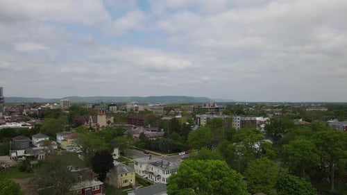 Luftaufnahme des etablierten Stadtviertels mit Kirche und Wohnhäusern mit Bäumen.