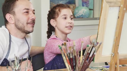 Proud Father Watching His Lovely Daughter Painting a Picture