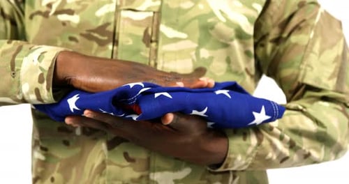 Soldier Folding American Flag in Camouflage Uniform