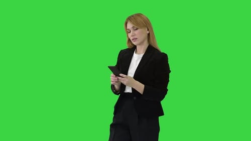 Beautiful and Happy Smiling Young Business Woman Interact with Phone Application on a Green Screen