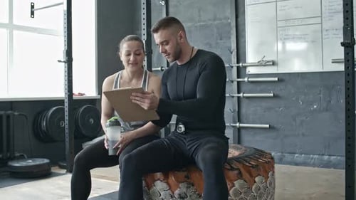 Cross Training Coach talking to Athletic Woman in Gym