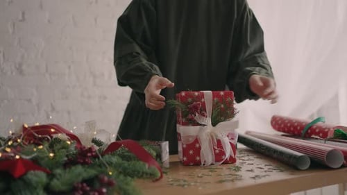 Young Adult Decorating Christmas Present at Home
