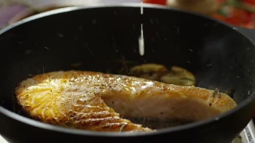 Lemon Juice Drizzled onto Fish in Skillet