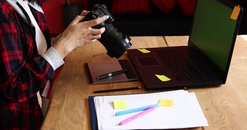 Photographer Female Working in a Creative Office Holding Camera at Desk and Retouch Photo