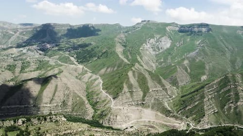 Rocky green mountains on cloudy sky background