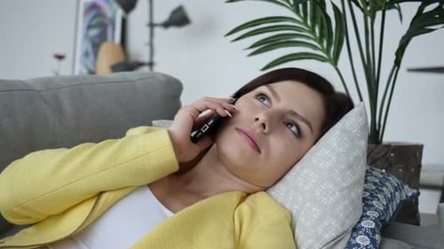 Woman Relaxing on Sofa Talking on Cellphone