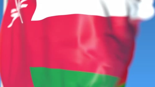 Oman National Flag Waving in Wind Against Blue Sky