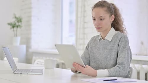 Young Latin Woman Using Tablet in Office