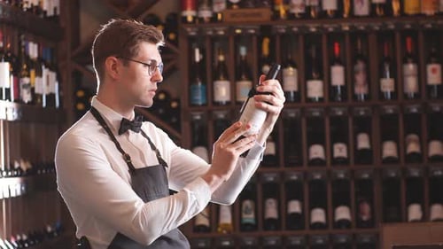 Man Examining Wine Bottle at Upscale Shop