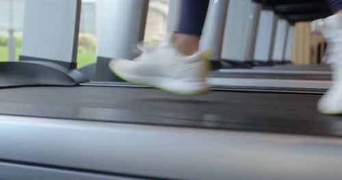 Woman legs run on the treadmill in gym room