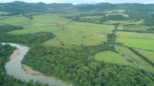 Aerial Drone View Beautiful Natural Scenery of Green Meadow with River Mountains in Background