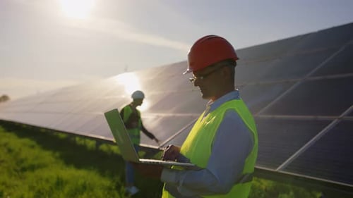 Porträt eines männlichen Solaringenieurs, der mit einem Tablet steht und in die Kamera schaut Ein anderer Mann