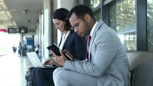 Business People Using Tech Devices at Urban Bus Station