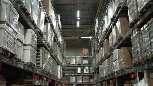 A Smooth Panorama of the Warehouse Huge Racks with Boxes of Goods Stand in Even Rows