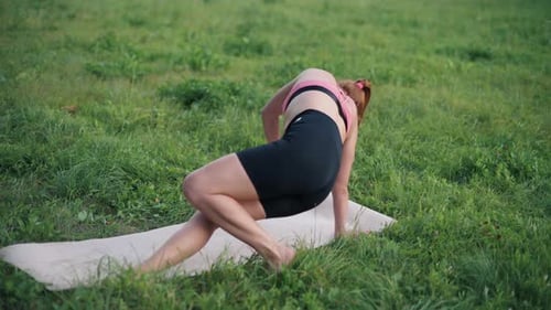 Woman Doing Yoga Exercise on Grass