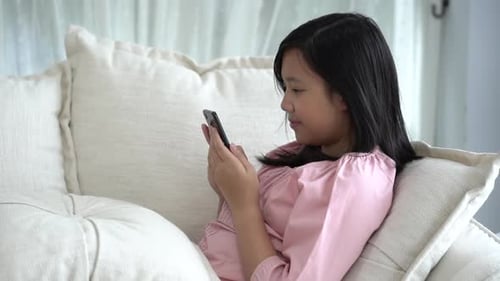 Girl Using Mobile Phone on Couch at Home