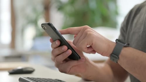 Hands of Young Man Using Smartphone Close Up