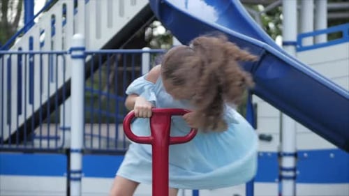 Happy Smiling Girl Outdoors, Child Playing on a Swing in the Park. Baby Emotions Concept. Summer
