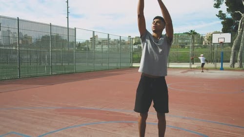 Young Man Practicing Basketball on Outdoor Court