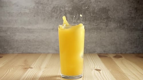 Ice Cube Splashing into Refreshing Orange Juice