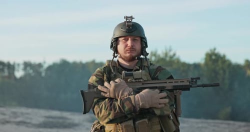 Portrait of Soldier Dressed in Moro Uniform Helmet and Equipment Belt Man Looks Into Camera Rifle of