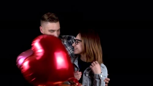 Romantic Young Couple Celebrating with Heart Balloons