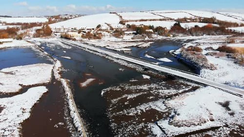 Snowy River and Bridge in Rural Winter Landscape