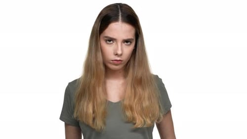 Porträt einer strengen brünetten Frau mit gefärbtem Haar, die den Zeigefinger auf den Lippen hält und darum bittet, zu behalten