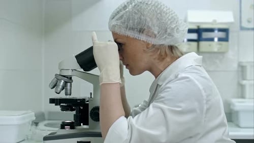 Young Adult Working With Microscope in Laboratory